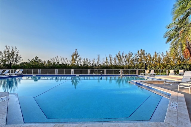 community pool featuring a hot tub, a patio, and fence