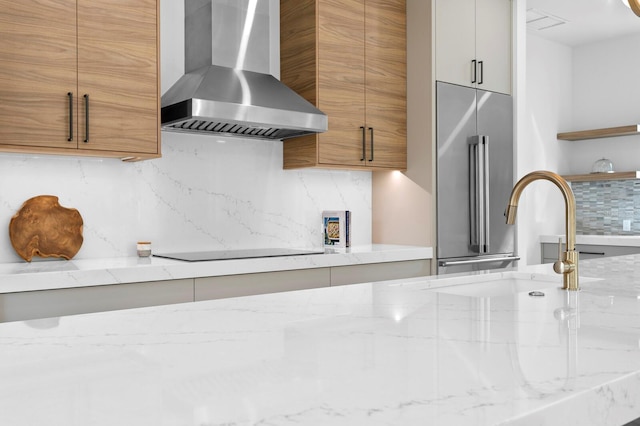 2554 Arlington St, Sarasota, FL 34239 - kitchen with tasteful backsplash, light stone countertops, modern cabinets, high end refrigerator, and wall chimney exhaust hood