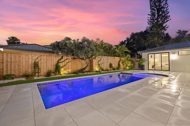 1559 Bay Rd, Sarasota, FL 34239 - pool at dusk featuring a fenced in pool, a fenced backyard, and a patio area
