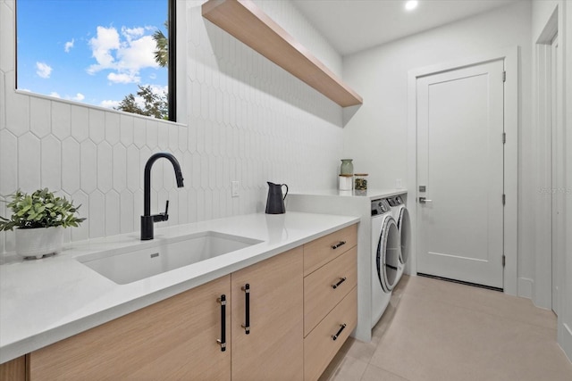 1559 Bay Rd, Sarasota, FL 34239 - clothes washing area with washer and dryer, light tile patterned flooring, and a sink