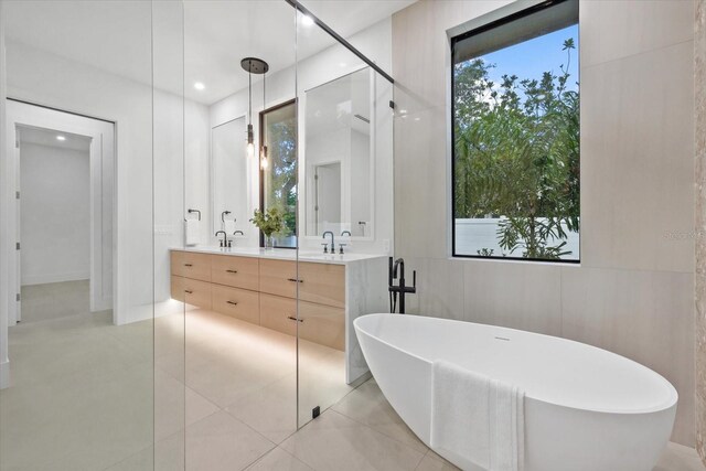 1559 Bay Rd, Sarasota, FL 34239 - full bath featuring double vanity, tile patterned floors, a sink, and a soaking tub