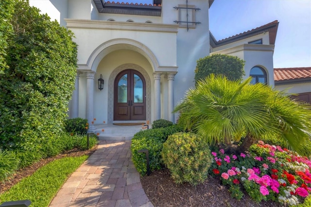 property entrance with stucco siding and a tile roof