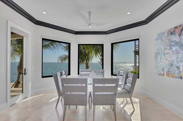 dining room with a water view, baseboards, a ceiling fan, and ornamental molding