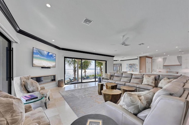 living area featuring visible vents, ornamental molding, and recessed lighting