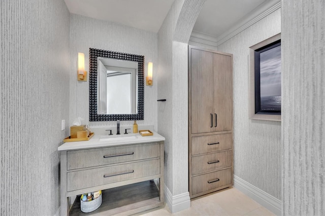 bathroom with baseboards, vanity, and wallpapered walls