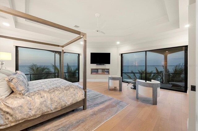 bedroom featuring a tray ceiling, crown molding, recessed lighting, and wood finished floors