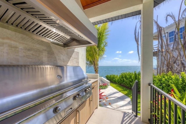 view of patio with a water view and area for grilling