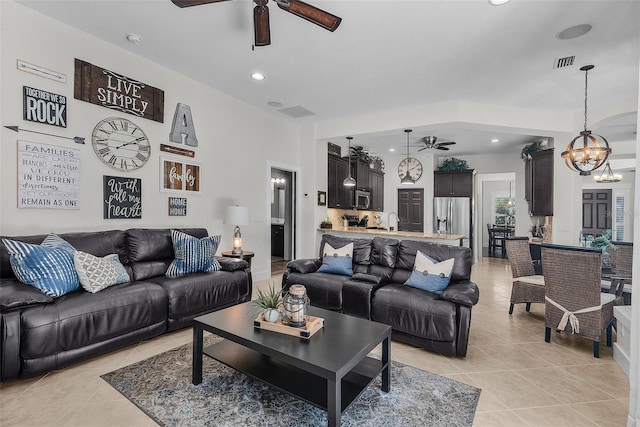 living area with recessed lighting, visible vents, light tile patterned floors, and ceiling fan with notable chandelier