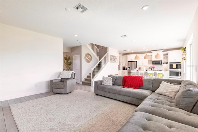 13422 Flat Woods Ter, Bradenton, FL 34211 - living room featuring stairway, light wood-style floors, and recessed lighting
