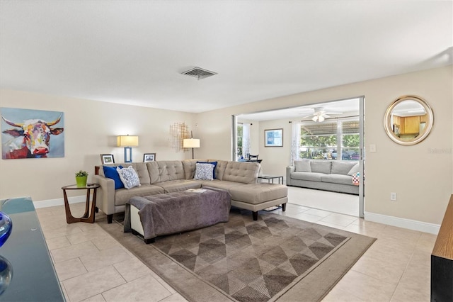 living area featuring baseboards, ceiling fan, visible vents, and light tile patterned floors