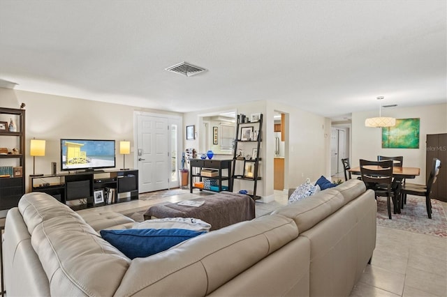 living area with visible vents and light tile patterned flooring