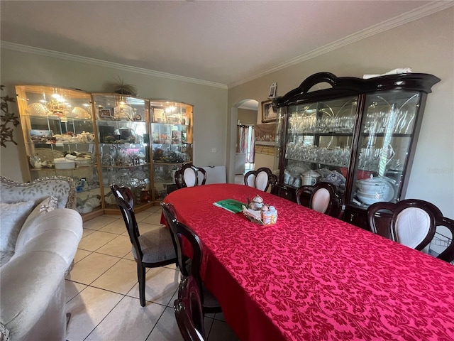 tiled dining room with arched walkways and ornamental molding