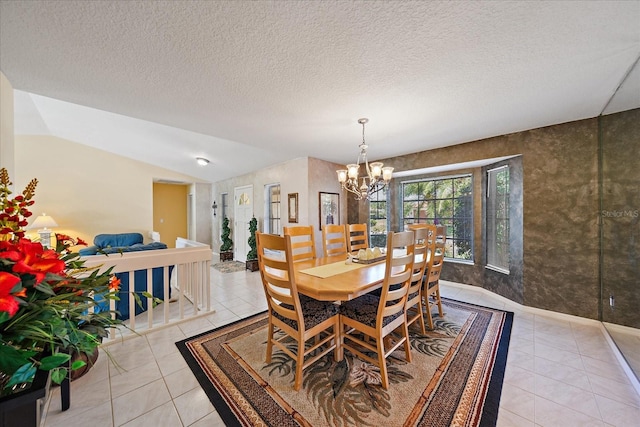 dining space featuring a chandelier, light tile patterned flooring, vaulted ceiling, a textured ceiling, and baseboards