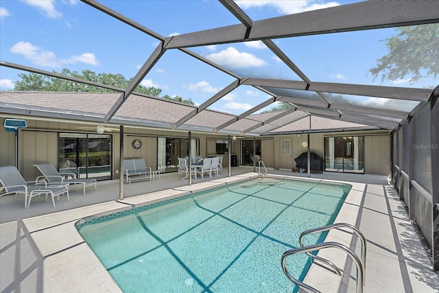 swimming pool with a patio area and glass enclosure