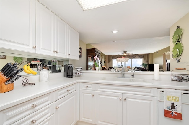 kitchen featuring a sink, dishwasher, white cabinetry, light countertops, and recessed lighting