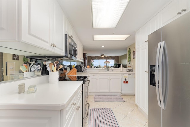 kitchen featuring stainless steel appliances, light tile patterned flooring, white cabinetry, and light countertops