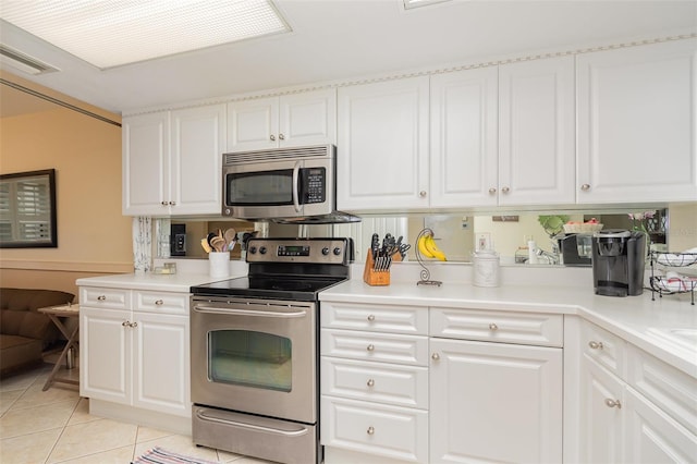 kitchen with appliances with stainless steel finishes, light tile patterned floors, white cabinetry, and light countertops