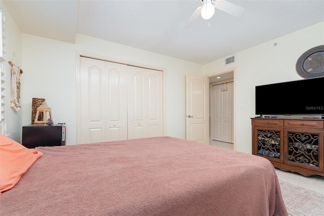 carpeted bedroom featuring a closet and ceiling fan
