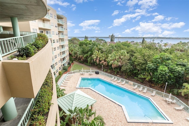 community pool with a water view and a patio area