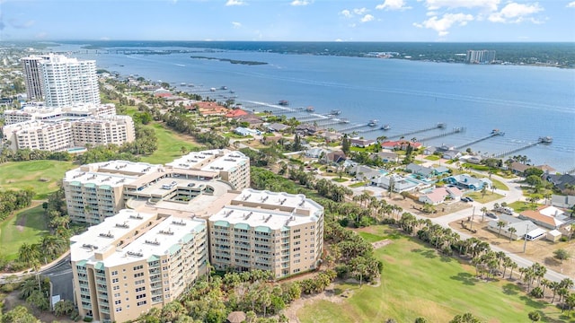 drone / aerial view of apartment complex, a nearby body of water, and a local golf course