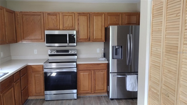 kitchen featuring light countertops, appliances with stainless steel finishes, and brown cabinets