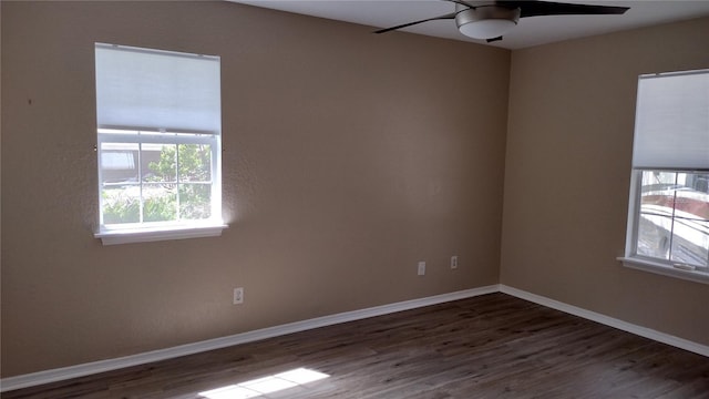 empty room featuring ceiling fan, baseboards, and wood finished floors