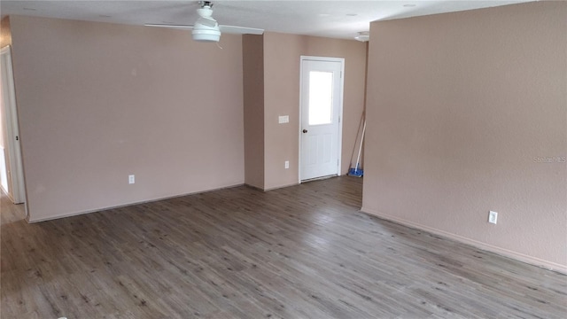 unfurnished room with baseboards, a ceiling fan, and wood finished floors