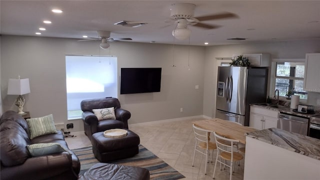 living room with a ceiling fan, visible vents, and recessed lighting