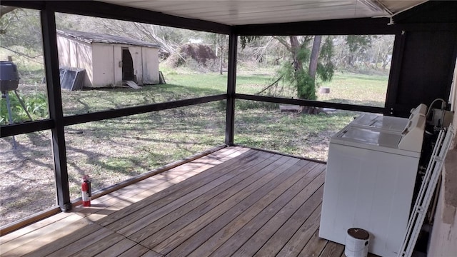 wooden deck featuring a yard, a storage shed, an outdoor structure, and washer and dryer