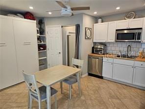 kitchen featuring a ceiling fan, recessed lighting, white cabinetry, backsplash, and stainless steel appliances