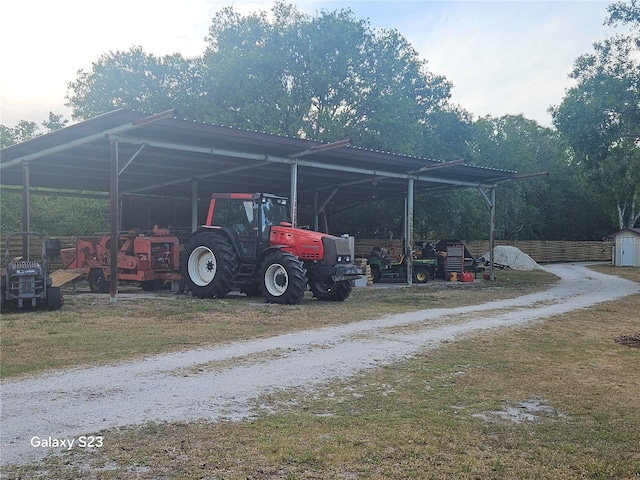view of vehicle parking featuring a detached carport and dirt driveway