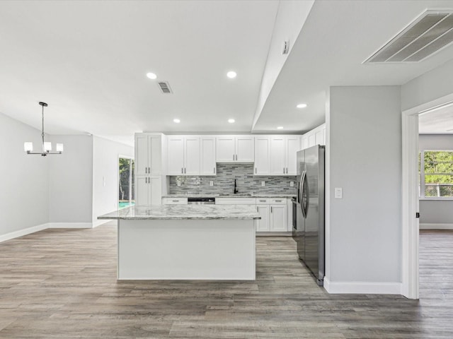 8304 Fishhawk Ave, New Port Richey, FL 34653 - kitchen with visible vents, baseboards, backsplash, and stainless steel fridge with ice dispenser
