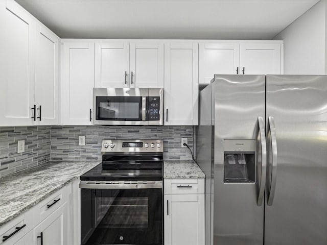 8304 Fishhawk Ave, New Port Richey, FL 34653 - kitchen featuring white cabinets, backsplash, appliances with stainless steel finishes, and light stone counters