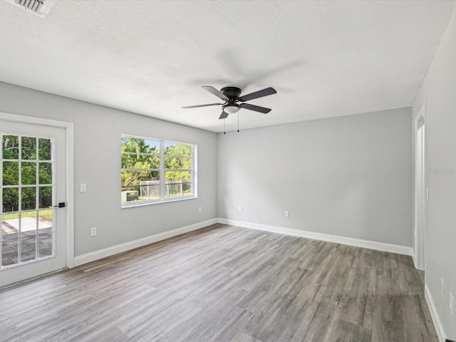 8304 Fishhawk Ave, New Port Richey, FL 34653 - spare room with visible vents, ceiling fan, wood finished floors, and a wealth of natural light
