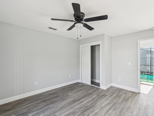 8304 Fishhawk Ave, New Port Richey, FL 34653 - unfurnished bedroom with visible vents, a closet, wood finished floors, baseboards, and ceiling fan