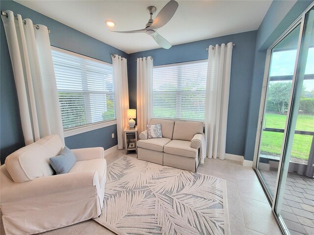 26017 Seastone Dr, Englewood, FL 34223 - living room with healthy amount of natural light, a ceiling fan, baseboards, and light tile patterned flooring