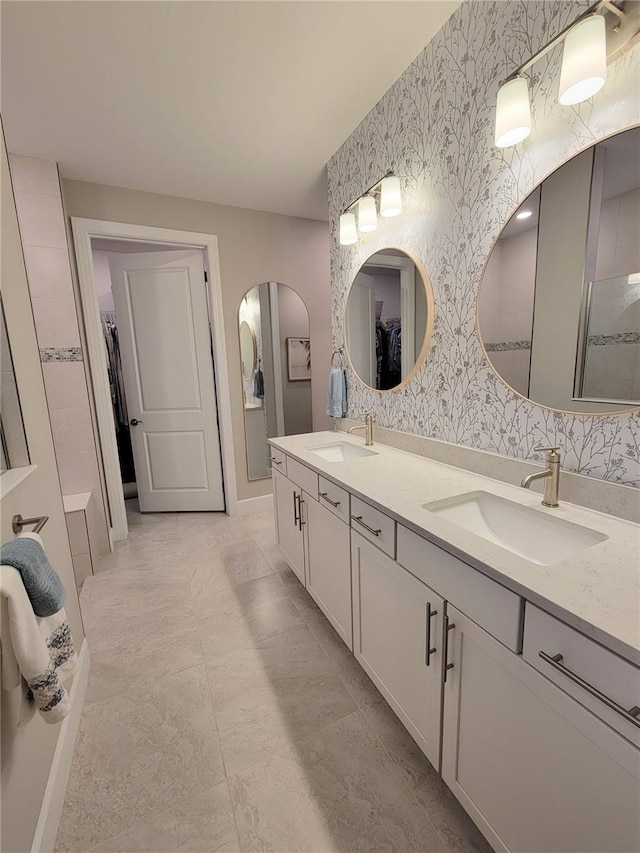 26017 Seastone Dr, Englewood, FL 34223 - full bathroom with wallpapered walls, double vanity, and a walk in closet
