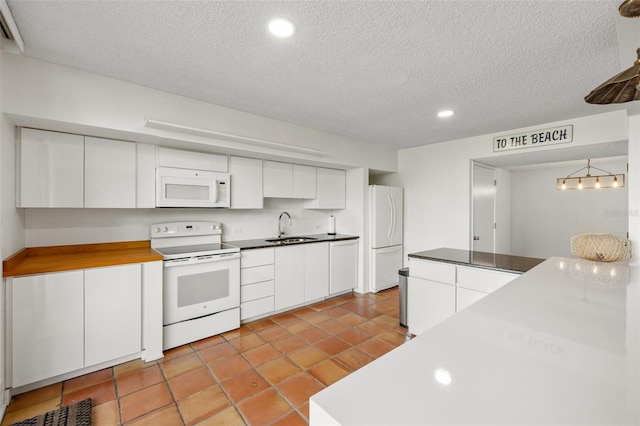 kitchen featuring a sink, white appliances, a textured ceiling, recessed lighting, and white cabinetry