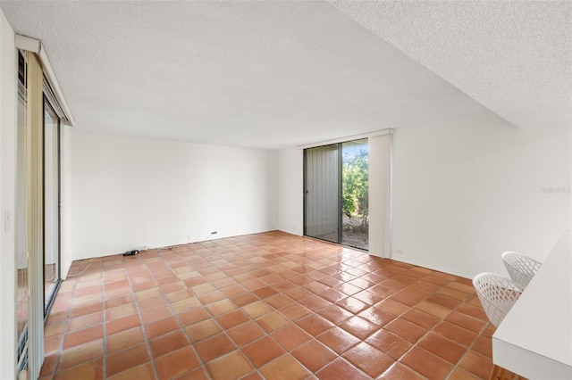 unfurnished room featuring tile patterned flooring, floor to ceiling windows, and a textured ceiling