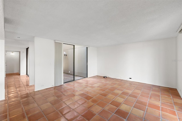 interior space with a closet, a textured ceiling, and tile patterned flooring