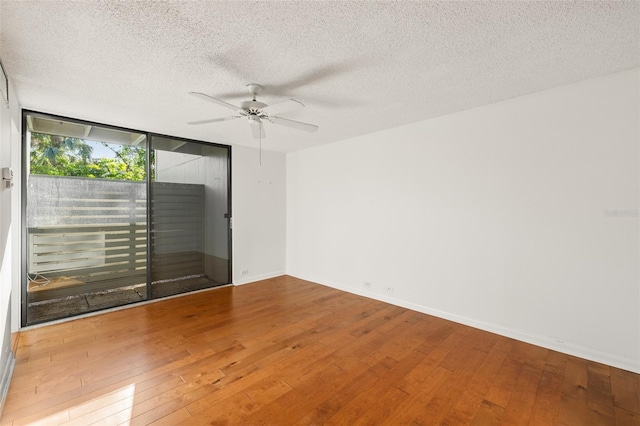 spare room with baseboards, a ceiling fan, a textured ceiling, and hardwood / wood-style floors