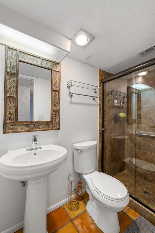 bathroom with toilet, tile patterned floors, baseboards, visible vents, and a stall shower