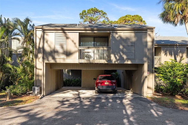view of front of home with a carport, driveway, and central AC