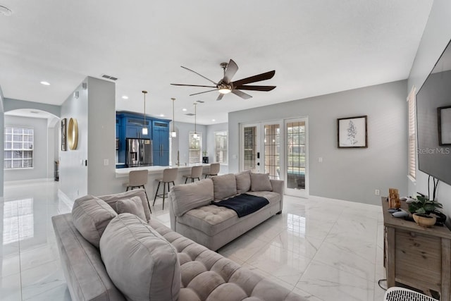 living area featuring ceiling fan, arched walkways, marble finish floor, recessed lighting, and visible vents