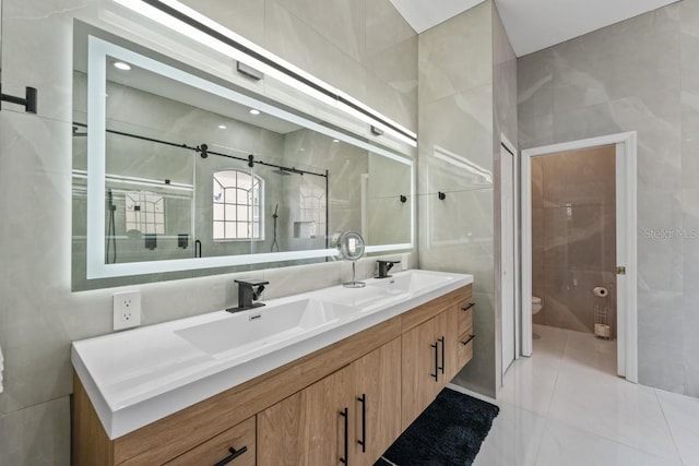 full bathroom with a sink, tile walls, toilet, and double vanity