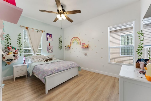 bedroom featuring baseboards, a ceiling fan, and light wood finished floors