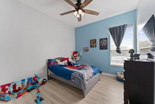 bedroom with baseboards, ceiling fan, and wood finished floors