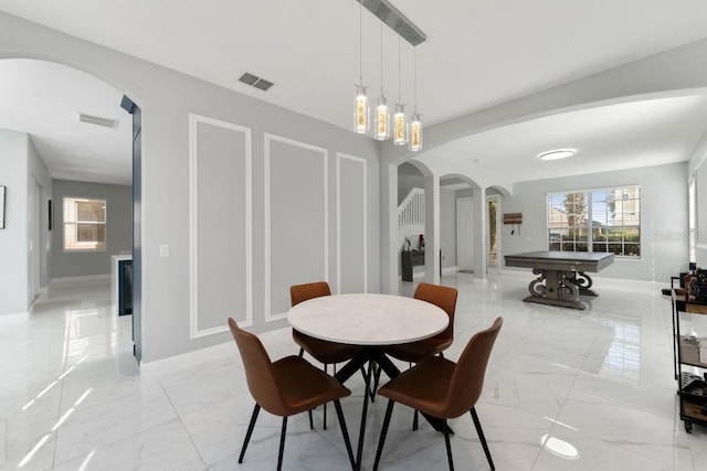dining space with arched walkways, visible vents, a healthy amount of sunlight, and marble finish floor
