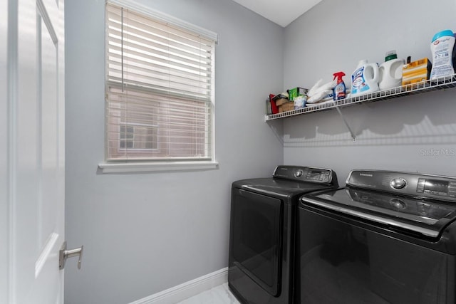 washroom with laundry area, marble finish floor, baseboards, and washing machine and dryer