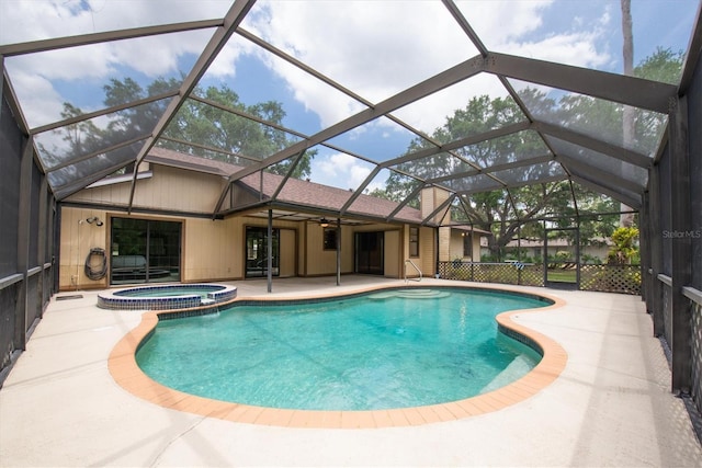 view of swimming pool with glass enclosure, ceiling fan, a pool with connected hot tub, and a patio area